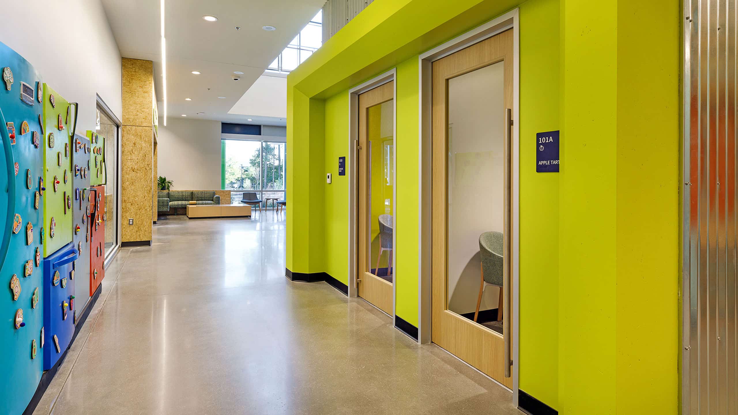 Brightly colored and decorated hall lined with doors at Feed More