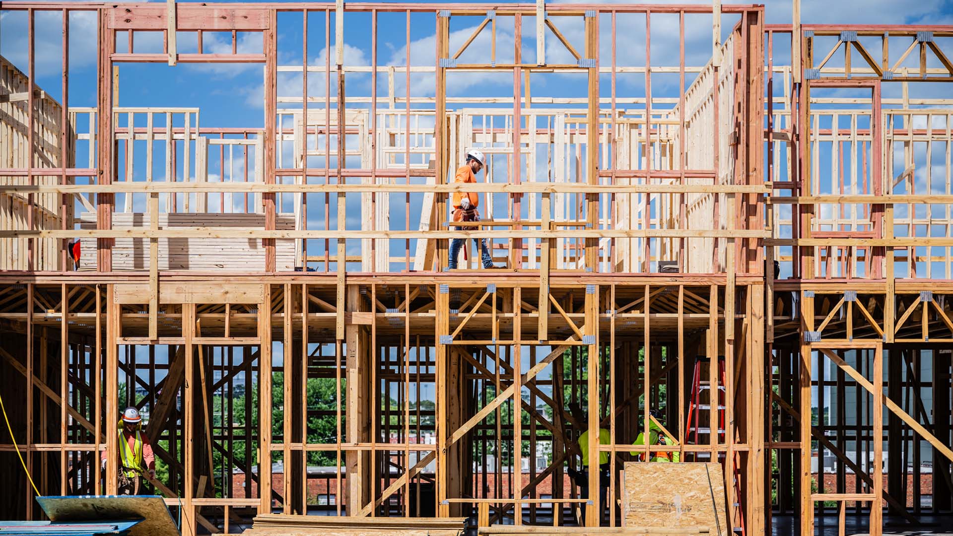 Workers in wooden frame of building