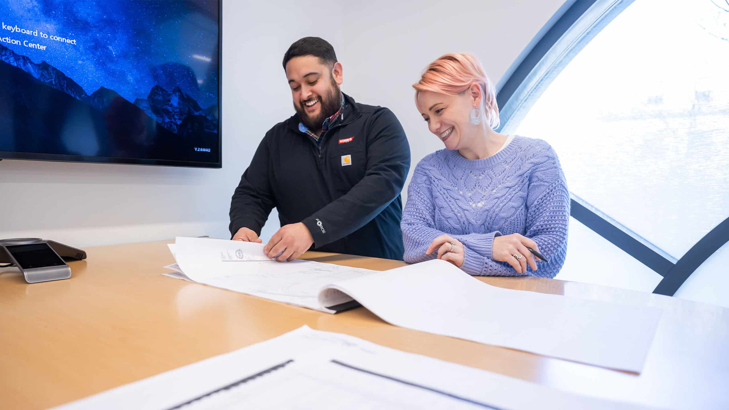 Two WORRKS employees looking at diagrams on paper