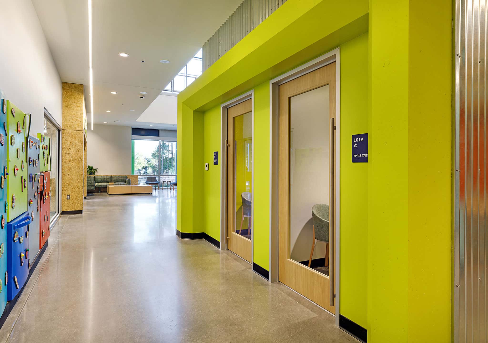 Brightly colored and decorated hall lined with doors at Feed More
