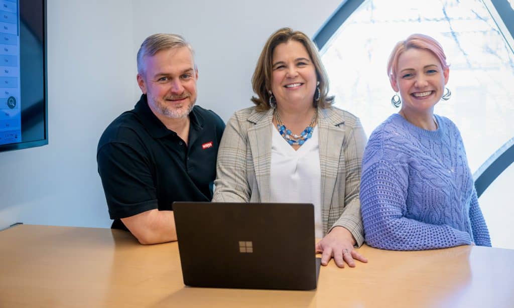 Three people smiling at camera