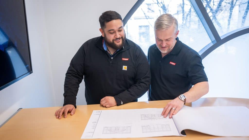 Two WORRKS employees looking at diagrams on paper